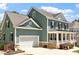 Charming two-story home featuring a white garage door, inviting porch and manicured landscaping at 309 Larkhaven Pl, Apex, NC 27539