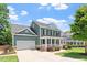 Charming two-story home with a welcoming front porch, landscaped yard, and attached garage provides curb appeal at 309 Larkhaven Pl, Apex, NC 27539