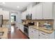 Well-lit kitchen featuring white cabinets, stainless steel appliances, and granite countertops at 309 Larkhaven Pl, Apex, NC 27539
