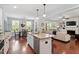 Open-concept kitchen connected to the living and dining areas features an island, stainless appliances, and lots of light at 309 Larkhaven Pl, Apex, NC 27539
