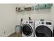 Organized laundry room with modern washer, dryer, and convenient shelving at 309 Larkhaven Pl, Apex, NC 27539