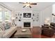 Inviting living room with hardwood floors, fireplace, and built-in shelving and cabinets surrounding the fireplace at 309 Larkhaven Pl, Apex, NC 27539