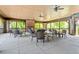 Covered outdoor patio featuring fireplace, multiple tables and chairs, and ceiling fans at 309 Larkhaven Pl, Apex, NC 27539