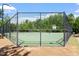 View of the fenced in community tennis court with trees in the background at 309 Larkhaven Pl, Apex, NC 27539