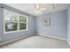 Carpeted bedroom with blue walls, a ceiling fan, and a large window at 309 Plank Bridge Way, Morrisville, NC 27560