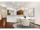 Bright dining area featuring a modern chandelier, a marble table, and an open view of the kitchen at 309 Plank Bridge Way, Morrisville, NC 27560