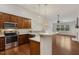 Open-concept kitchen featuring stainless steel appliances, wood cabinets, and counter seating at 309 Plank Bridge Way, Morrisville, NC 27560