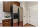 Updated kitchen features stainless steel fridge, granite counters, and wood cabinets at 309 Plank Bridge Way, Morrisville, NC 27560