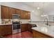 Kitchen featuring wood cabinets, stainless appliances, and stone countertops at 309 Plank Bridge Way, Morrisville, NC 27560