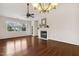 Open living room with a ceiling fan, a fireplace, hardwood floors, and large windows for natural light at 309 Plank Bridge Way, Morrisville, NC 27560