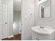 Well-lit bathroom with a pedestal sink, vanity mirror, and a view of the hallway at 310 Bay Dr, Cary, NC 27511