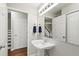 This bathroom features a pedestal sink, large mirror and a neutral color palette at 310 Bay Dr, Cary, NC 27511
