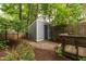 Backyard shed with landscaping, a secure door, and surrounded by lush greenery at 310 Bay Dr, Cary, NC 27511