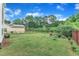 Large backyard with a black fence, green grass, custom patio, and trees at 3449 S Beaver Ln, Raleigh, NC 27604