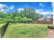 Expansive backyard with a fire pit patio, black fence, lush green grass and mature trees at 3449 S Beaver Ln, Raleigh, NC 27604