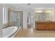 Well-lit bathroom with a large tub, glass enclosed shower and double sink vanity at 3449 S Beaver Ln, Raleigh, NC 27604