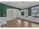 Dining room with wood-look floors, white wainscoting, and natural light from two windows at 3449 S Beaver Ln, Raleigh, NC 27604