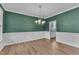 Spacious dining room showcases wood-look floors, wainscoting, and an elegant chandelier at 3449 S Beaver Ln, Raleigh, NC 27604