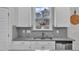 Kitchen sink and white cabinets beneath window with herringbone backsplash and granite countertop at 3449 S Beaver Ln, Raleigh, NC 27604