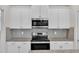 Close up of stainless steel microwave and range with white cabinets and granite countertops at 3449 S Beaver Ln, Raleigh, NC 27604