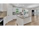 Open kitchen with granite island, white cabinets, stainless steel appliances, and hardwood flooring at 3449 S Beaver Ln, Raleigh, NC 27604