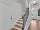 Elegant staircase with wooden steps, iron railings, and a view of the entryway at 3449 S Beaver Ln, Raleigh, NC 27604