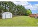 Image of the expansive backyard, including a storage shed, a well-maintained lawn, and beautiful trees at 366 E Smithfield St, Angier, NC 27501