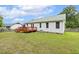 View of the backyard, featuring a deck, vinyl siding, well-kept lawn, and lush landscaping at 366 E Smithfield St, Angier, NC 27501