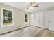 Bright bedroom features two windows, wood-look flooring, ceiling fan, and double closets at 366 E Smithfield St, Angier, NC 27501