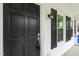 Close-up of the front door with black paint, side windows, and classic hardware at 366 E Smithfield St, Angier, NC 27501