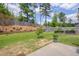 A vast backyard featuring lush green grass, tiered garden beds, fire pit, and a wood fence for privacy at 40 Bourne Dr, Franklinton, NC 27525