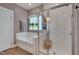 Bright bathroom showcasing a tub, glass enclosed shower, and a window at 40 Bourne Dr, Franklinton, NC 27525