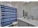 Well-lit bathroom featuring a vanity with marble countertops, chrome fixtures, and a shower with a stylish blue curtain at 40 Bourne Dr, Franklinton, NC 27525