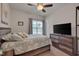 Cozy bedroom features a queen-sized bed, carpet floors, a ceiling fan, and a dresser with a large TV at 40 Bourne Dr, Franklinton, NC 27525