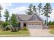 Charming home featuring stone accents, a gray two-car garage, an American flag, and a beautifully landscaped front yard at 40 Bourne Dr, Franklinton, NC 27525