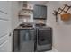 Convenient laundry room featuring modern front-loading washer and dryer, shelving and patterned wallpaper at 40 Bourne Dr, Franklinton, NC 27525