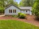 Backyard view of light blue home with lush, mature landscaping at 4004 Bamburgh Ln, Apex, NC 27539