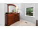 Bedroom showcasing a dark wood dresser beneath a window, offering a serene and organized space at 4004 Bamburgh Ln, Apex, NC 27539