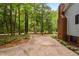 Expansive driveway with lush green surroundings and a glimpse of the brick exterior and mature trees at 4004 Bamburgh Ln, Apex, NC 27539