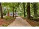 Charming home with blue siding, brick chimney, and private setting amidst mature trees at 4004 Bamburgh Ln, Apex, NC 27539
