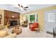 Cozy living room with brick fireplace, ceiling fan, and a bay window view at 4004 Bamburgh Ln, Apex, NC 27539