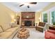 Comfortable living room with brick fireplace, ceiling fan, and cozy seating at 4004 Bamburgh Ln, Apex, NC 27539