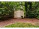 Charming backyard outbuilding surrounded by mature trees and lush greenery, offering ample storage at 4004 Bamburgh Ln, Apex, NC 27539