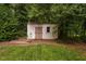 Additional backyard outbuilding, surrounded by greenery, offering versatile storage options at 4004 Bamburgh Ln, Apex, NC 27539