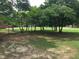 An open backyard with a lush green lawn surrounded by mature shade trees at 4024 Rural Retreat Rd, Burlington, NC 27215