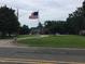 Exterior shot of a brick house with a sprawling front yard, trees, and an American flag at 4024 Rural Retreat Rd, Burlington, NC 27215