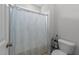 Compact bathroom featuring a toilet, shower with patterned curtain, and essential toiletries storage at 408 Torwood Cir, Apex, NC 27523