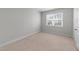 A cozy bedroom features neutral carpet, white walls and trim, with a window for natural light at 408 Torwood Cir, Apex, NC 27523