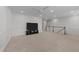 Expansive bonus room with carpet flooring, a TV setup, and staircase at 408 Torwood Cir, Apex, NC 27523