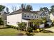 Side view of a two-story home with gray siding, complemented by a well-manicured lawn and lush landscaping at 408 Torwood Cir, Apex, NC 27523